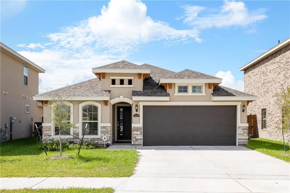 View of front of property featuring stucco siding, stone siding, and an attached garage