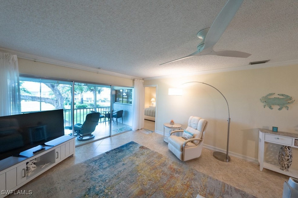 Living room featuring ornamental molding, a textur