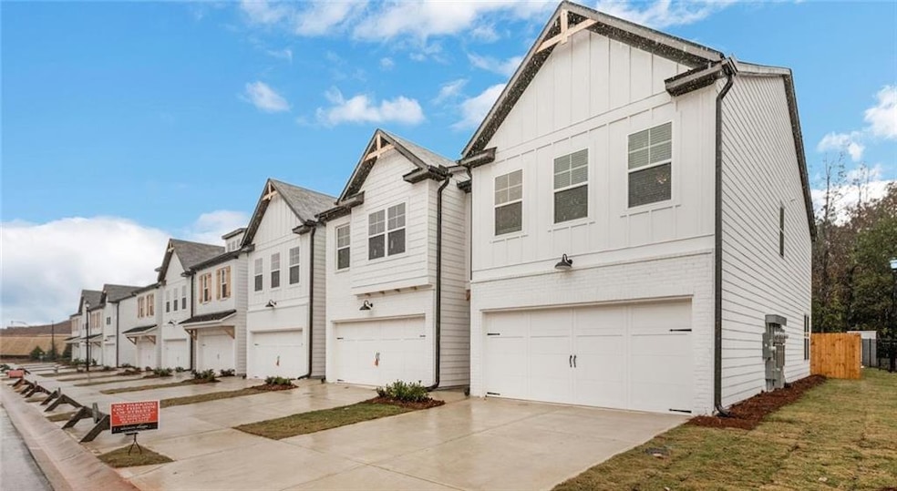 View of front facade featuring board and batten siding, a garage, concrete driveway, and a residential view