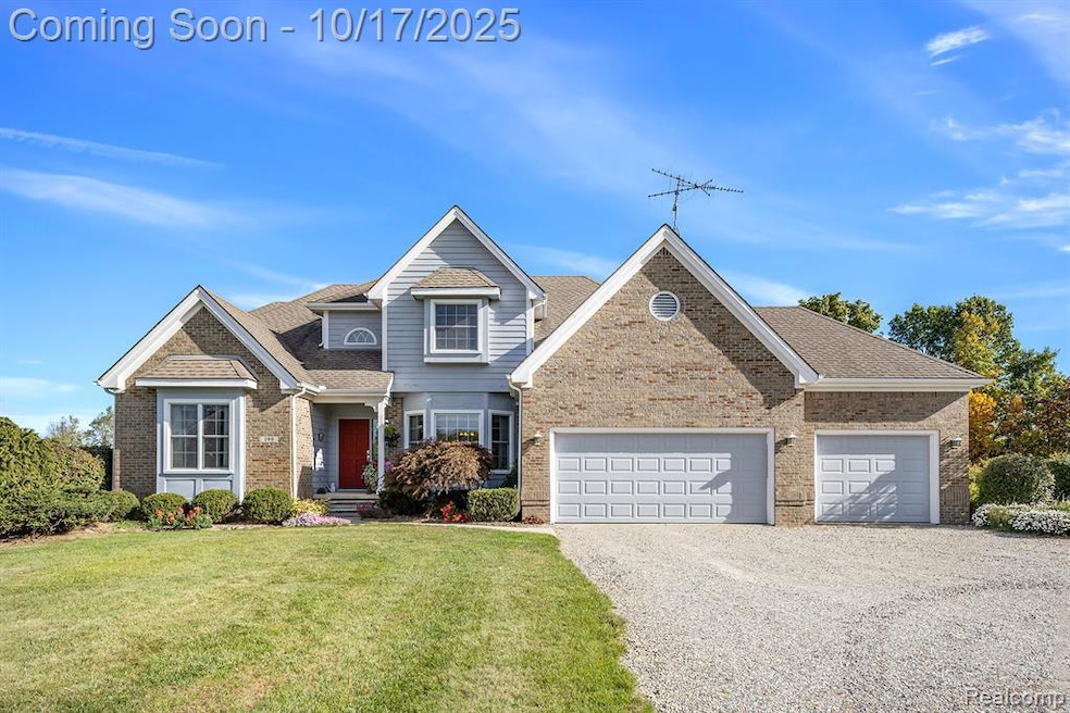 View of front of property featuring driveway, brick siding, roof with shingles, a front lawn, and an attached garage