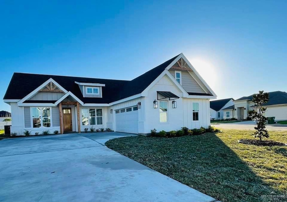 View of front of property with a garage and a front lawn