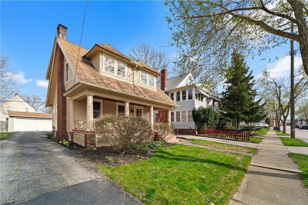 View of front facade with covered porch, a garage, and a front lawn