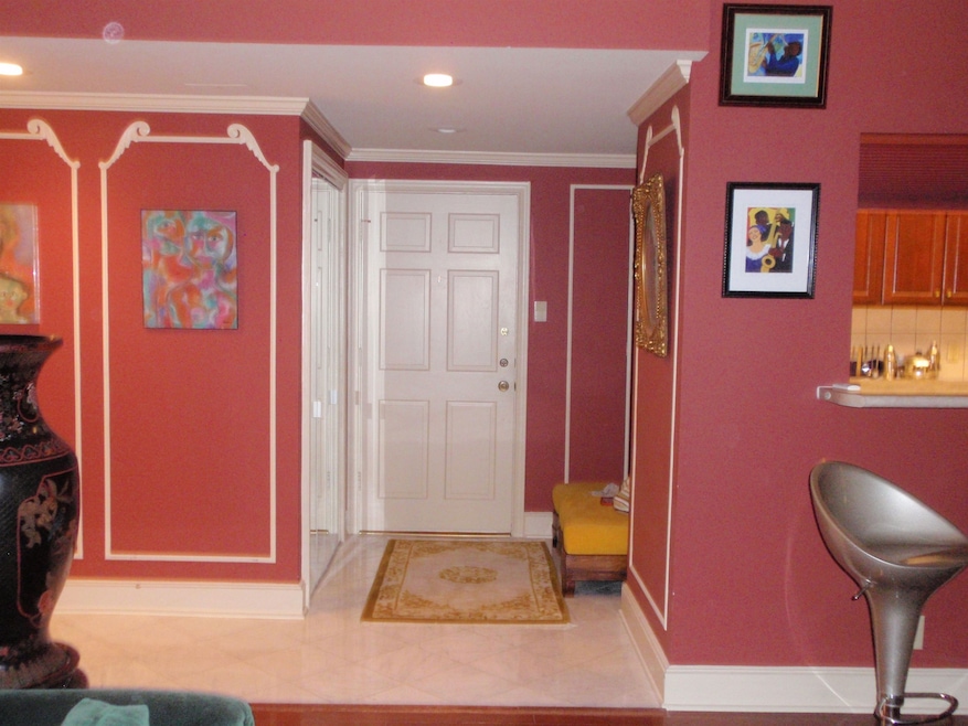 Tiled foyer entrance featuring ornamental molding and recessed lighting