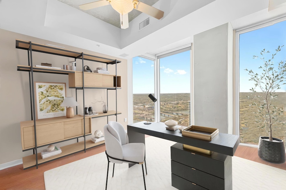 Home office featuring baseboards, a raised ceilin