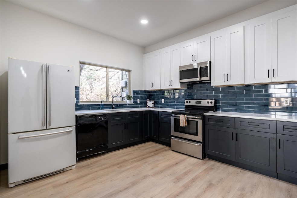 Kitchen featuring light countertops, a sink, ligh