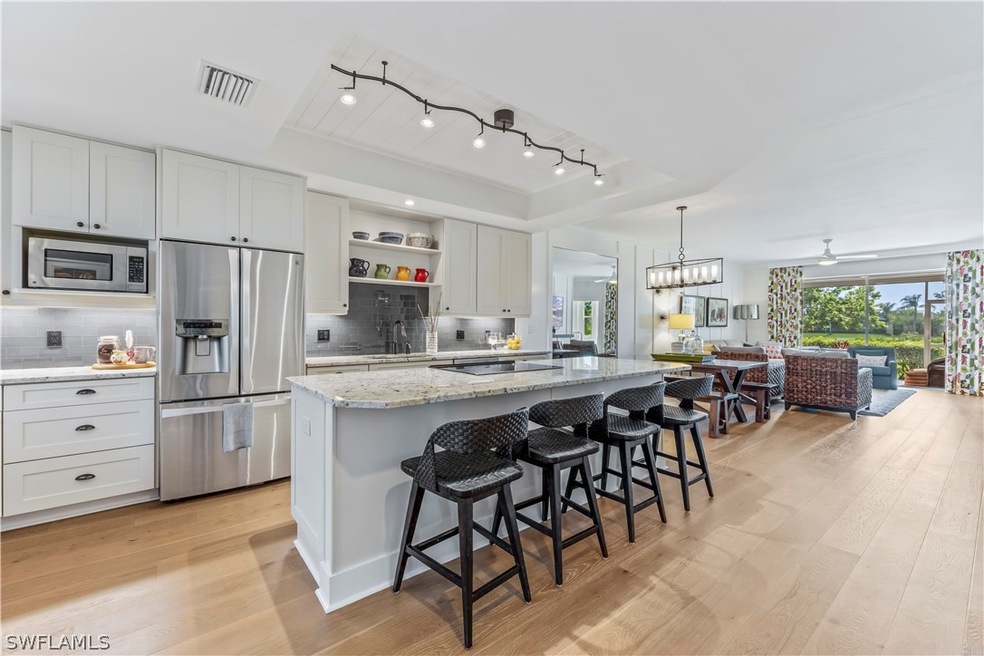 Kitchen through living with light wood-flooring,