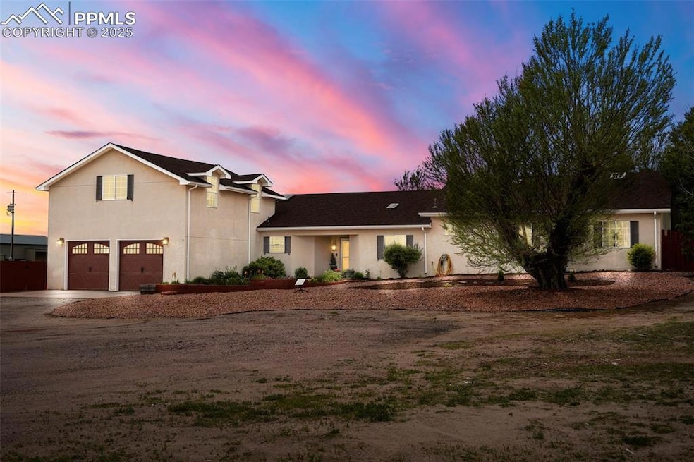 View of front of property featuring driveway, a garage, and stucco siding