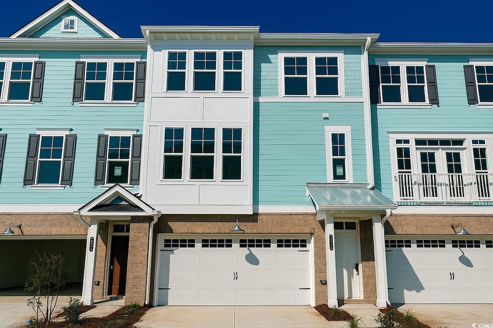 View of front facade with concrete driveway, brick siding, and an attached garage