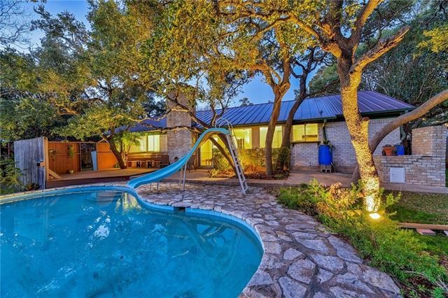 Rare deep pool with slide and open deck. Temporary flood lights added in this photo to highlight gorgeous oak trees in backyard!
