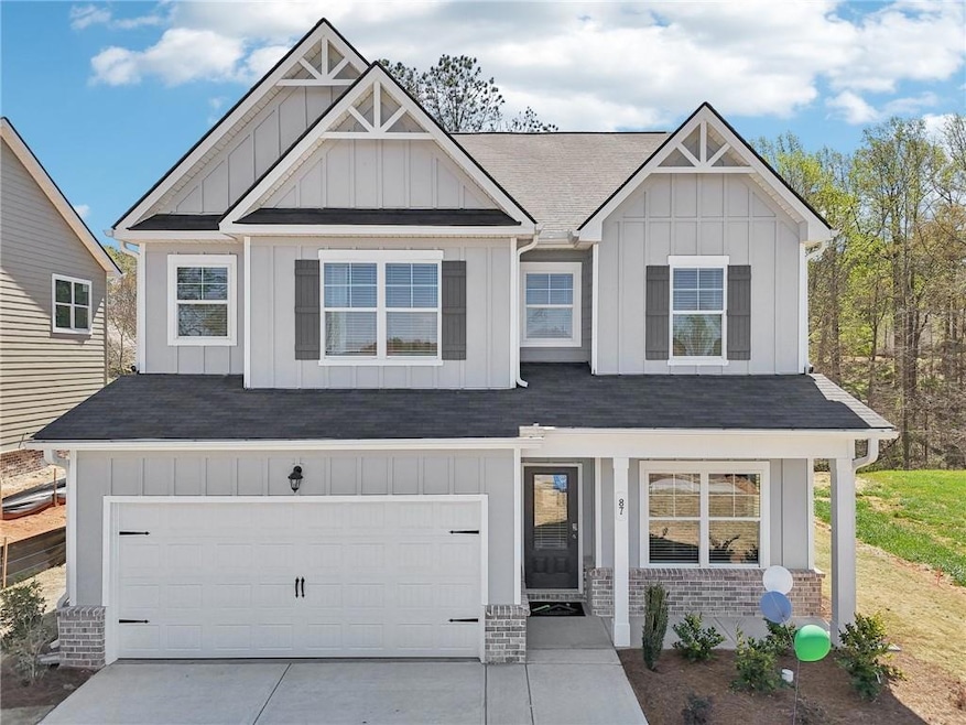 View of front facade featuring board and batten siding, a porch, concrete driveway, and a garage