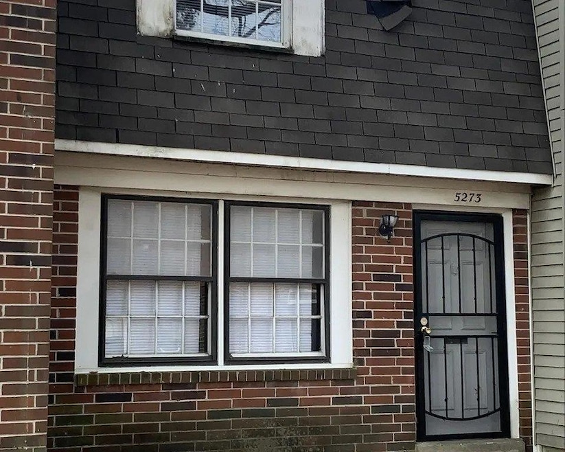 View of exterior entry with brick siding
