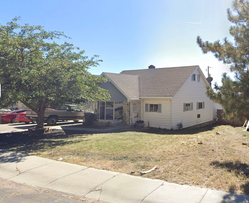 View of front of home featuring a front yard and a shingled roof