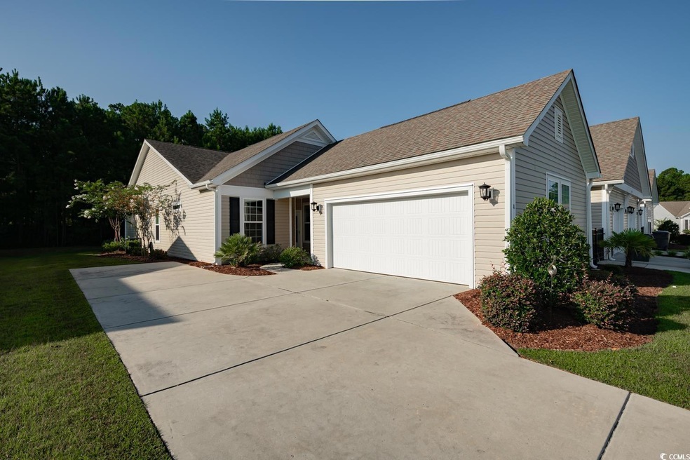 Ranch-style house featuring a garage and a front y