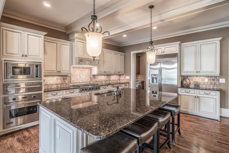 Gourmet kitchen with detailed cabinetry and granit