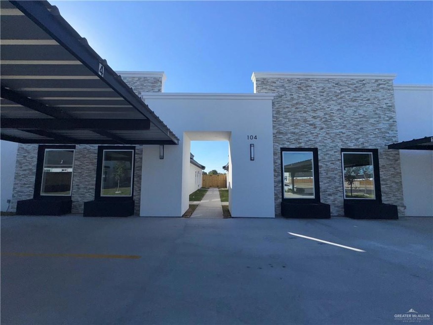 Property entrance featuring stone siding, parking, and stucco siding