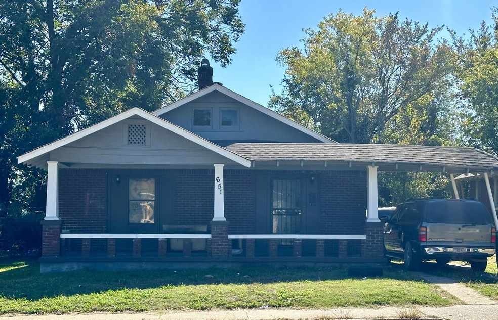 View of front facade with a front lawn, covered po