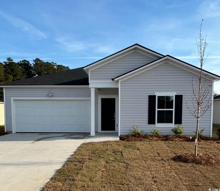 Single story home featuring a front yard and a gar