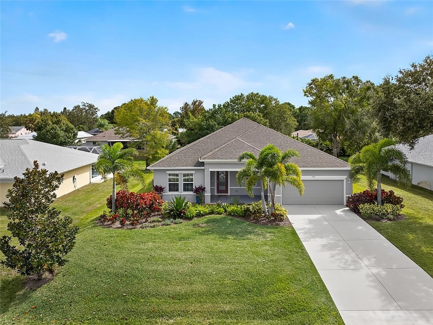 Single story home featuring a front yard, a shingled roof, and driveway