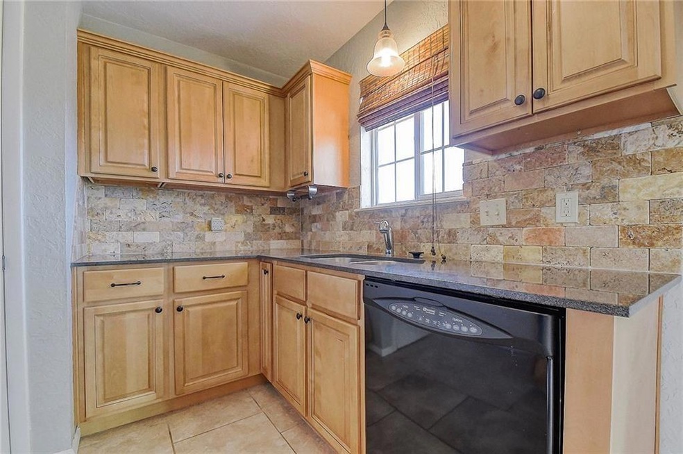 Kitchen featuring tasteful backsplash, dark stone 