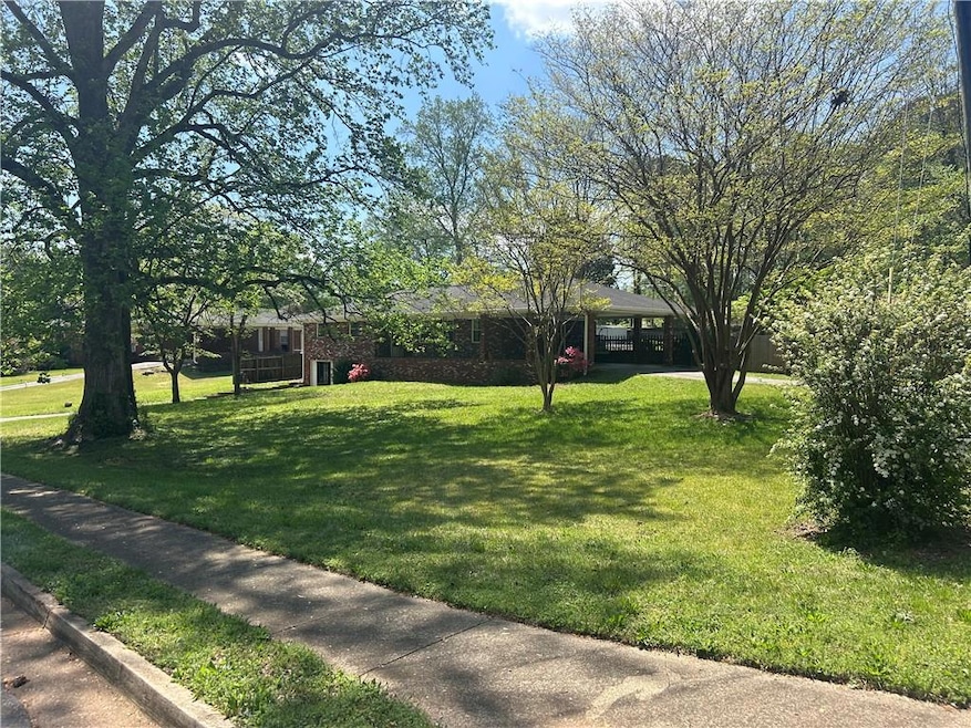 View of home with a big yard and a carport