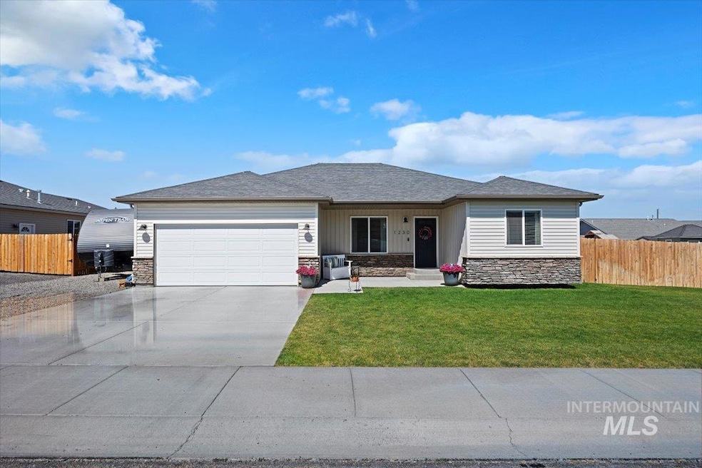 View of front of property with stone siding, a garage, concrete driveway, and roof with shingles