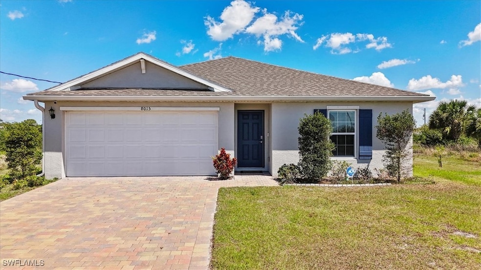 Single story home featuring stucco siding, an attached garage, decorative driveway, and a front yard