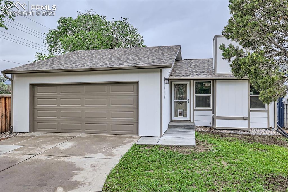 Ranch-style home with concrete driveway, an attached garage, roof with shingles, and a front yard
