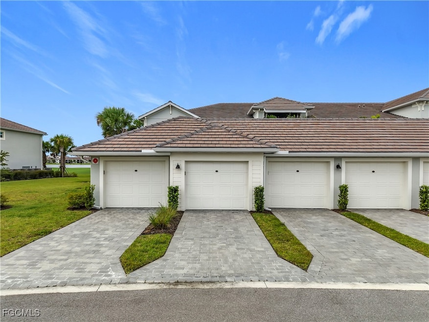 View of front of house featuring a tile roof and a front lawn