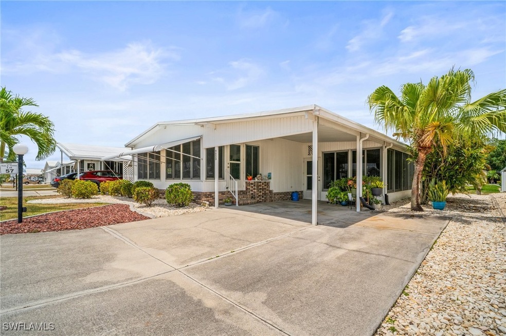 Rear view of house with driveway, a sunroom, and a