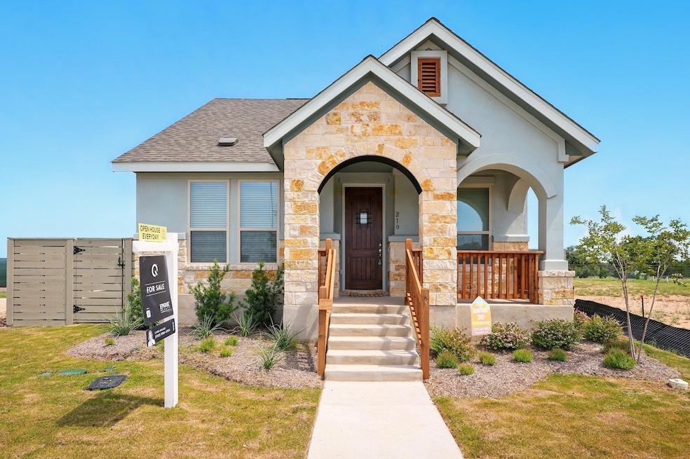 View of front facade featuring stone siding, a sh