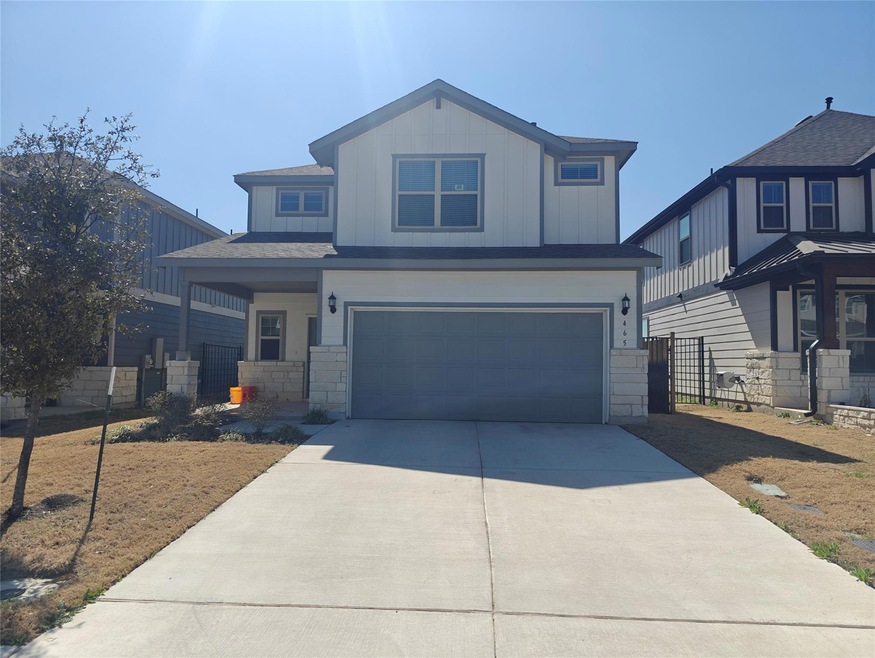 View of front of home with fence, driveway, a gar