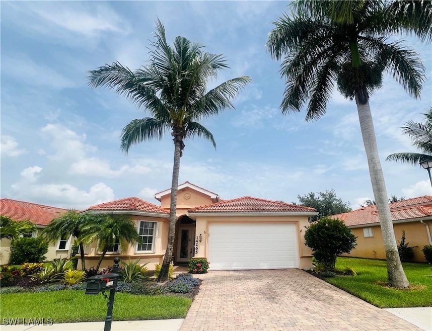 Mediterranean / spanish-style home featuring a gar