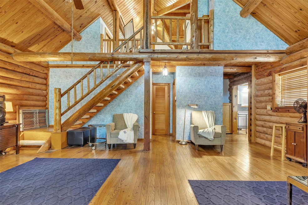 Living room featuring rustic walls, high vaulted 