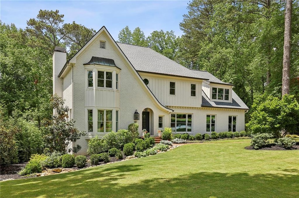View of front of property with a chimney, brick si