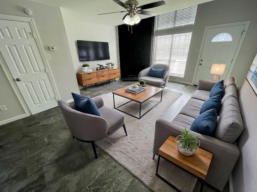 Living area with ceiling fan and baseboards