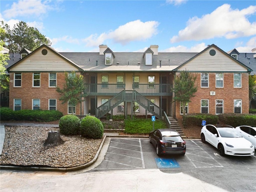 View of building exterior featuring stairs and uncovered parking