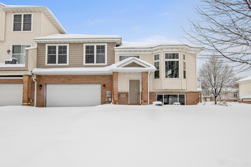 Exterior view from the front spotlights a two car garage and windows on each level.