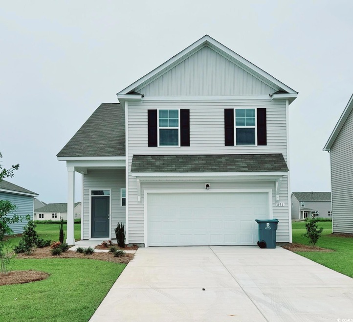 View of front facade with a garage and a front law