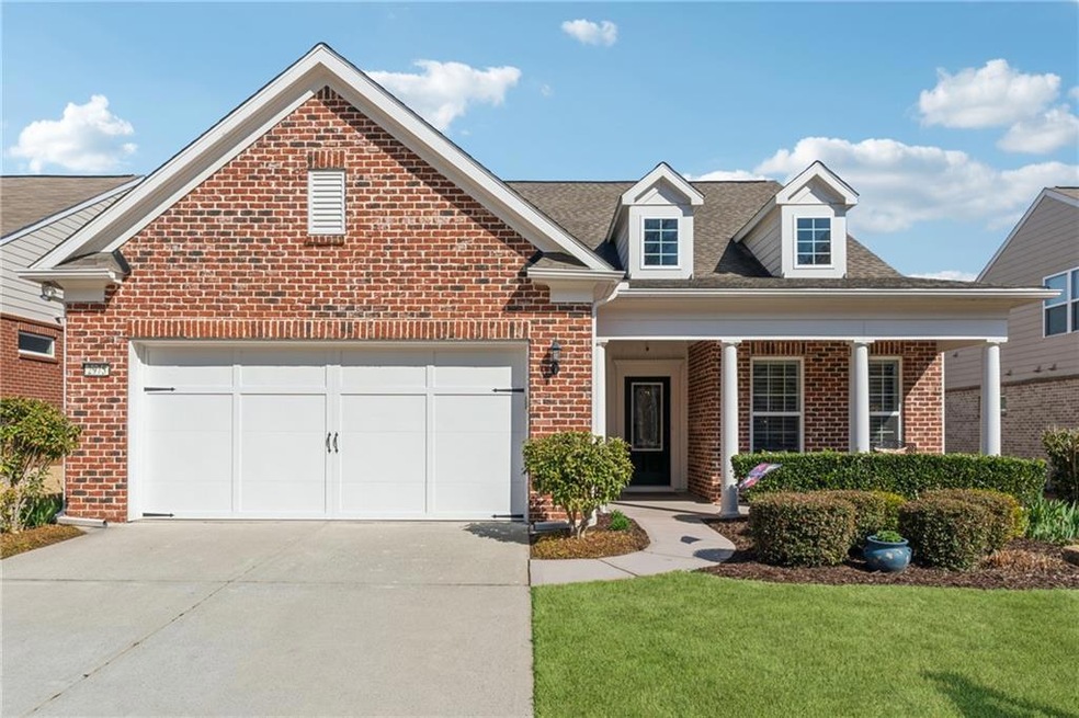 View of front facade featuring a garage, brick sid