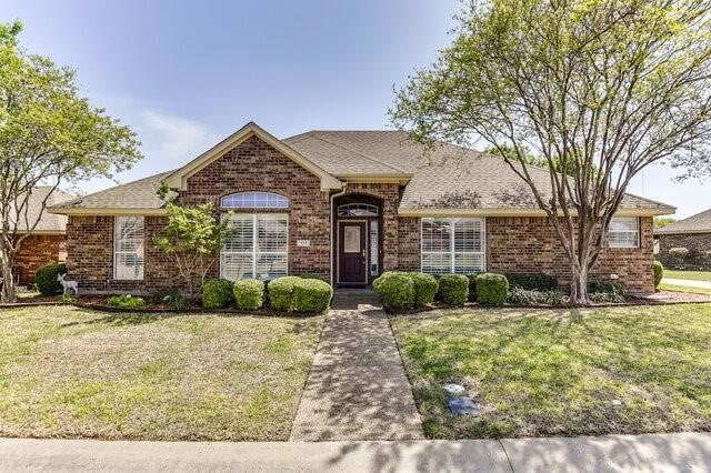 Ranch-style home with a front yard, a shingled roo