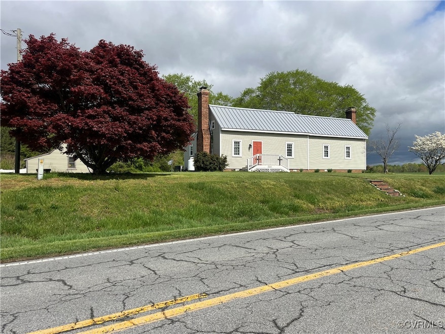 View of front of property with a chimney, metal ro