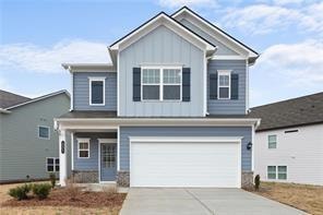 Craftsman inspired home featuring board and batten siding, concrete driveway, and a garage