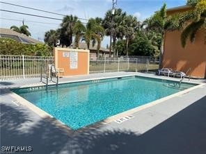 Community pool featuring a patio and fence