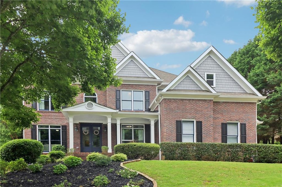 View of front of house featuring a front yard, french doors, and brick siding