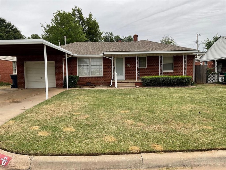 Ranch-style home featuring a front lawn, a carport, and a garage