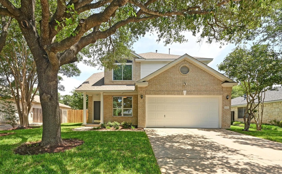 View of front facade with concrete driveway, a ga