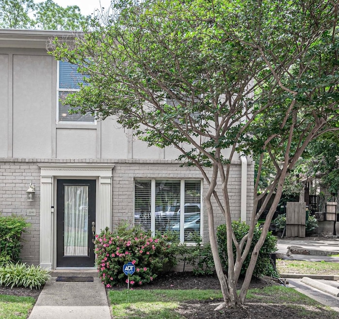 Property entrance featuring brick siding and stucco siding