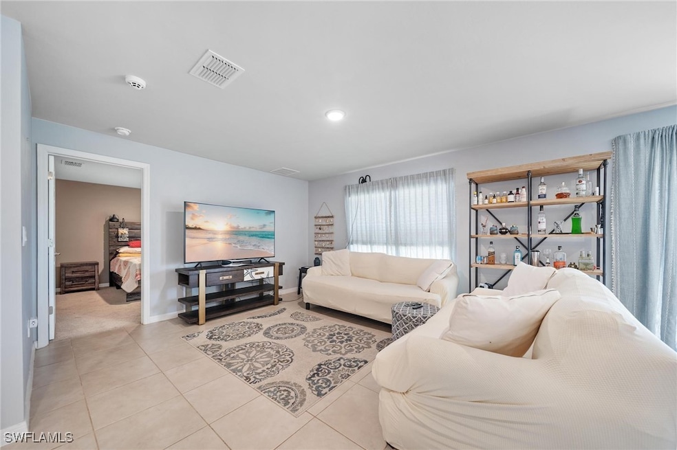 Living area featuring baseboards, visible vents, recessed lighting, and light tile patterned floors