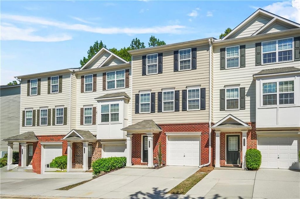 Multi unit property featuring driveway, brick siding, and an attached garage