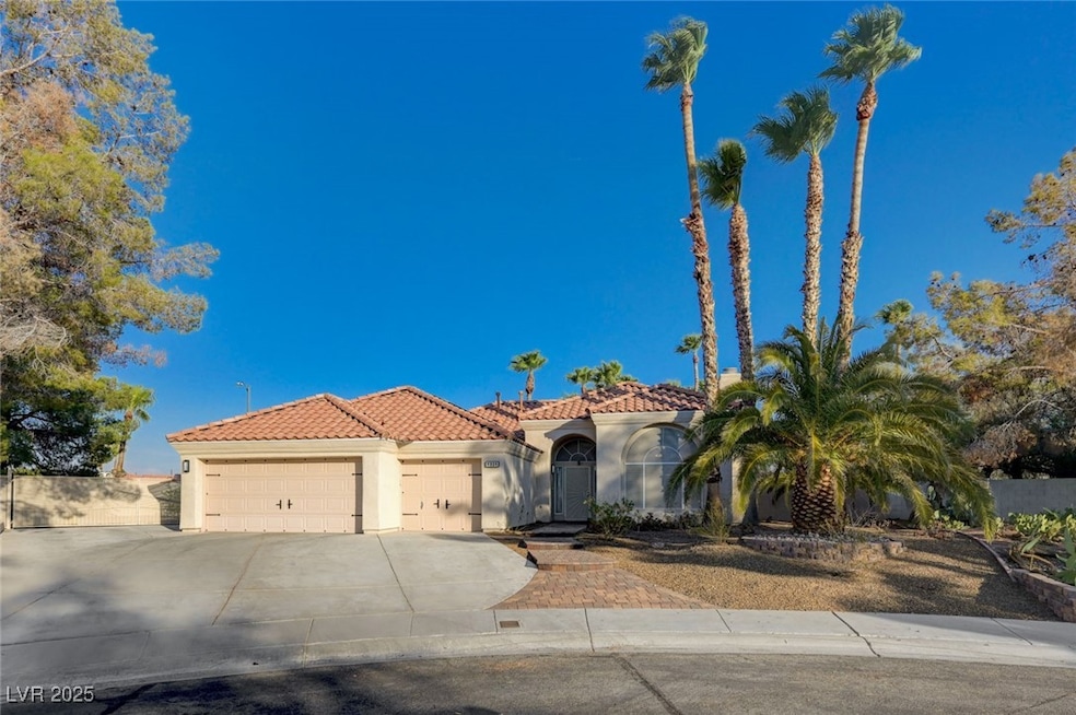 Mediterranean / spanish-style house featuring a garage, a tiled roof, stucco siding, and driveway